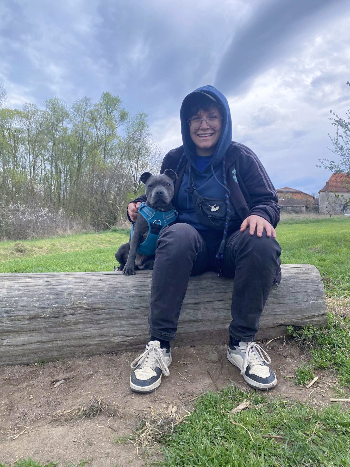 Adély assise dehors avec son chien